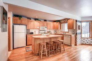 a kitchen with wooden cabinets and a island with bar stools at Village Townhomes in Frisco