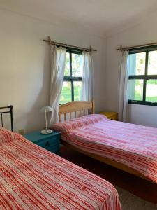 a bedroom with two beds and two windows at Tranquilo entorno campestre in Treinta y Tres