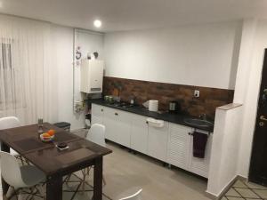 uma cozinha com uma mesa e uma bancada em Sweet Home em Buzau