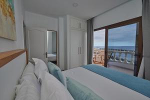 a bedroom with a bed with a view of the ocean at ABLANCAS - La Restinga in La Restinga