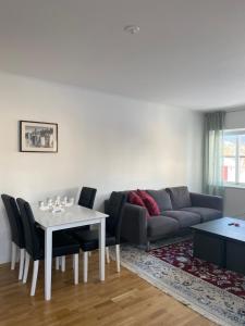 uma sala de estar com um sofá, uma mesa e cadeiras em VARIJLYAN em Sälen