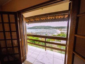 una puerta abierta a un balcón con vistas a la playa en Estalagem Vista Mar, en Arraial do Cabo