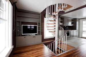 a living room with a staircase and a television at Mosetertoppen Panorama anneks 3B in Hafjell