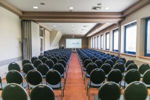 an empty room with chairs and a projector screen at Hotel Festival in Opole