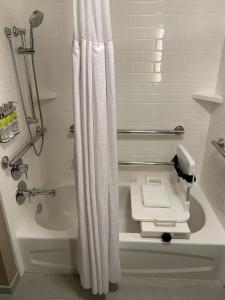 La salle de bains blanche est pourvue d'une douche, d'une baignoire et d'un lavabo. dans l'établissement Staybridge Suites - Vero Beach, an IHG Hotel, à Vero Beach