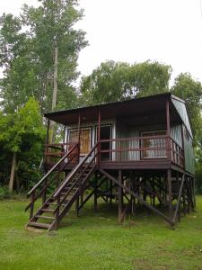 a tree house with a deck on the grass at Los Sauces in Tigre
