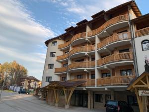 an apartment building with wooden balconies on a street at Apartman LN Zlatibor in Zlatibor
