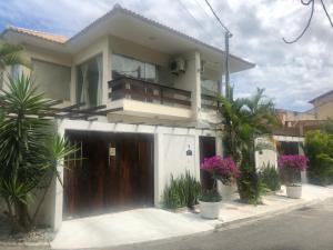 a house with a gate and flowers in front of it at Villa Vitoria in Cabo Frio