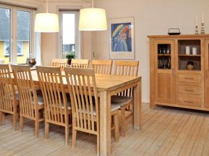 Holiday home Thyborøn IV في Thyborøn: غرفة طعام مع طاولة وكراسي خشبية