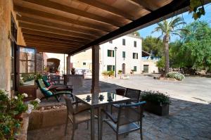 patio ze stołem i krzesłami oraz budynek w obiekcie Finca Son Sureda Agroturismo w Manacorze