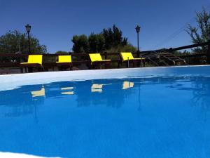 カピージャ・デル・モンテにあるCABAÑAS SAN ANTONIOの黄色い椅子と青い水のあるプール