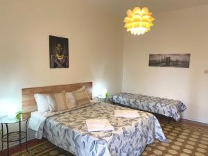 a bedroom with two beds and a chandelier at Al Fluviale in Ferrara