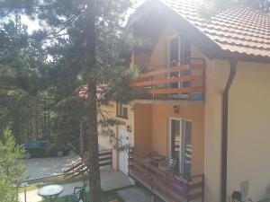 a house with a balcony and a tree at Mountain House Tara Apartmani Nikolic in Kaludjerske Bare
