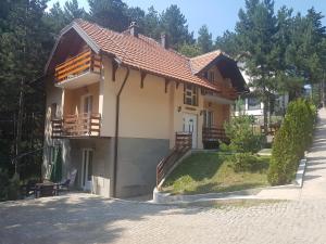 a small house with a porch and a driveway at Mountain House Tara Apartmani Nikolic in Kaludjerske Bare