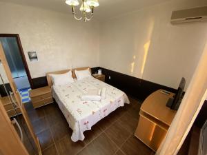 ロオにあるPioner Hotelのベッドとテーブル付きの小さな部屋