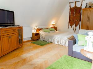 a bedroom with a bed and a flat screen tv at Lovely Apartment in Rusko with Pool Garden in Darłowo