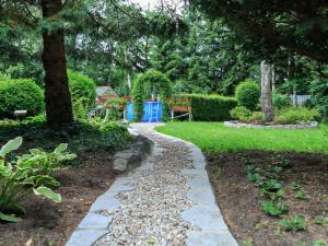 a stone path in a garden with a tree at Lovely Apartment in Rusko with Pool Garden in Darłowo