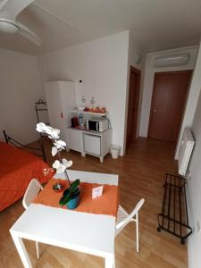 uma sala de estar com uma mesa branca e uma cozinha em Like Home Cisanello em Pisa