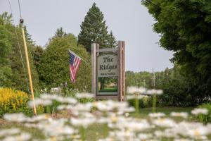 a sign for the rifles with an american flag and flowers at Ridges Inn & Suites in Baileys Harbor