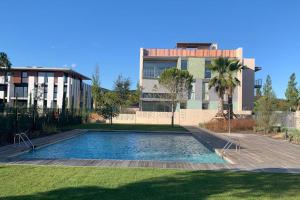 - une piscine dans une cour en face d'un bâtiment dans l'établissement Jardins d'Aro, à Platja d'Aro