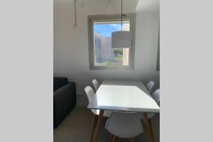 a white table and chairs in a room with a window at Jardins d'Aro in Platja  d'Aro