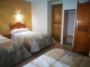 una habitación de hotel con 2 camas en una habitación en Cortijo Los Soledad en El Sauco