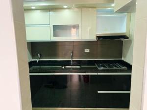 a kitchen with white cabinets and a sink at Apartamento Vacacional Toscana Melgar in Melgar