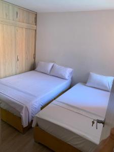 dos camas sentadas una al lado de la otra en una habitación en Apartamento Vacacional Toscana Melgar, en Melgar