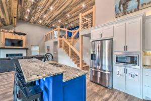 eine Küche mit weißen Schränken und einer blauen Insel in der Unterkunft Upscale Riverfront Home with Beach and Fire Pit! in Glenwood