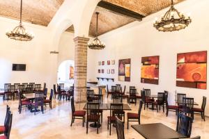 comedor con mesas, sillas y pinturas en las paredes en Hotel Ex-Hacienda San Xavier, en Guanajuato