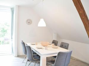 une salle à manger avec une table et des chaises blanches dans l'établissement Ferienhof Ostarle, à Arle
