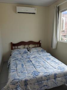 a bed with a blue and white quilt in a bedroom at Casa em Maragogi in Maragogi
