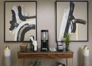 uma máquina de café sobre uma mesa num quarto com pinturas em Best Western Plus Desoto em Olive Branch