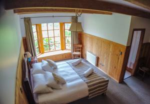 Cama grande en habitación con ventana grande en Andes Lodge, Puelo Patagonia, en Puelo