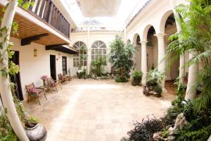 une cour intérieure avec des plantes dans un bâtiment dans l'établissement Hotel Casa Selah, à San Cristóbal de Las Casas