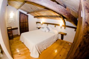 a bed in a room with a wooden floor at Hotel Casa Selah in San Cristóbal de Las Casas