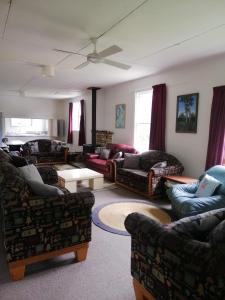 a living room with several couches and a table at Taylor Lodge in Erua