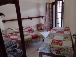 two beds in a room with a quilt at Casa Paraty in Paraty