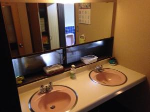 baño con 2 lavabos y espejo grande en Kiyotaki Ryokan, en Hikone