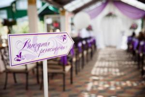 a sign in front of a row of chairs at a wedding at Petrovsky Dvorik in Vozdvizhenskoye