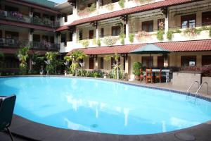 einem großen blauen Pool vor einem Gebäude in der Unterkunft Cakra Kembang Hotel in Yogyakarta