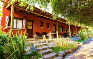 ein orangenes Haus mit einem Steinpfad davor in der Unterkunft Posada de campo Maia in Merlo