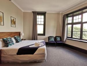 a bedroom with a large bed and two chairs at Sydney Crecy Hotel in Sydney