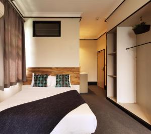 a bedroom with a bed and a large window at Sydney Crecy Hotel in Sydney