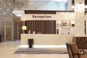 un'area reception in un edificio con un cartello che legge la ricezione di Forbis Hotel a Serang