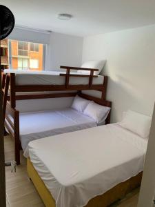 two bunk beds in a room with a window at Apartamento Vacacional Toscana Melgar in Melgar
