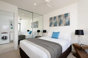 a bedroom with a bed and a washing machine at Park Avenue - IKON Glen Waverley in Glen Waverley