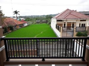 a balcony of a house with a green yard at Homestay Ayuning Kuningan in Jalaksana