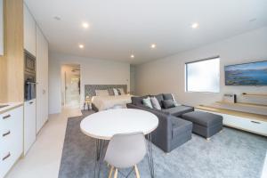 a living room with a bed and a couch and a table at Remarkable Studio in convenient Frankton in Frankton Wharf