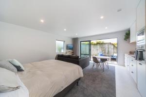 a bedroom with a bed and a kitchen with a table at Remarkable Studio in convenient Frankton in Frankton Wharf